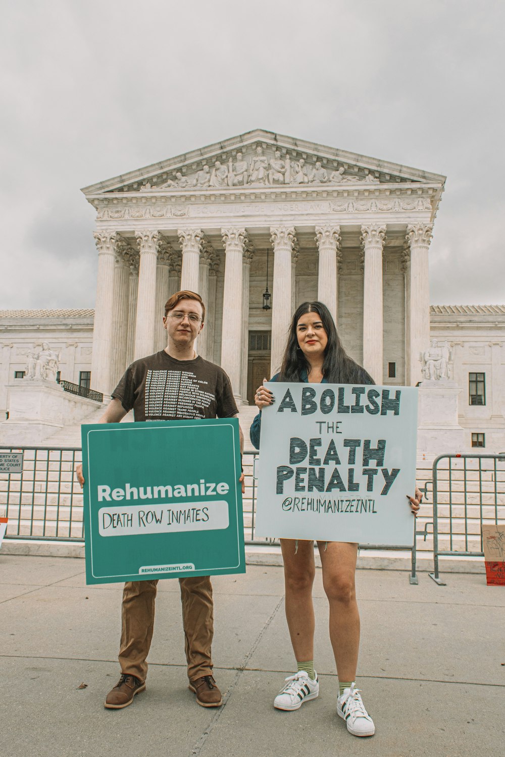 two people holding signs in front of a building