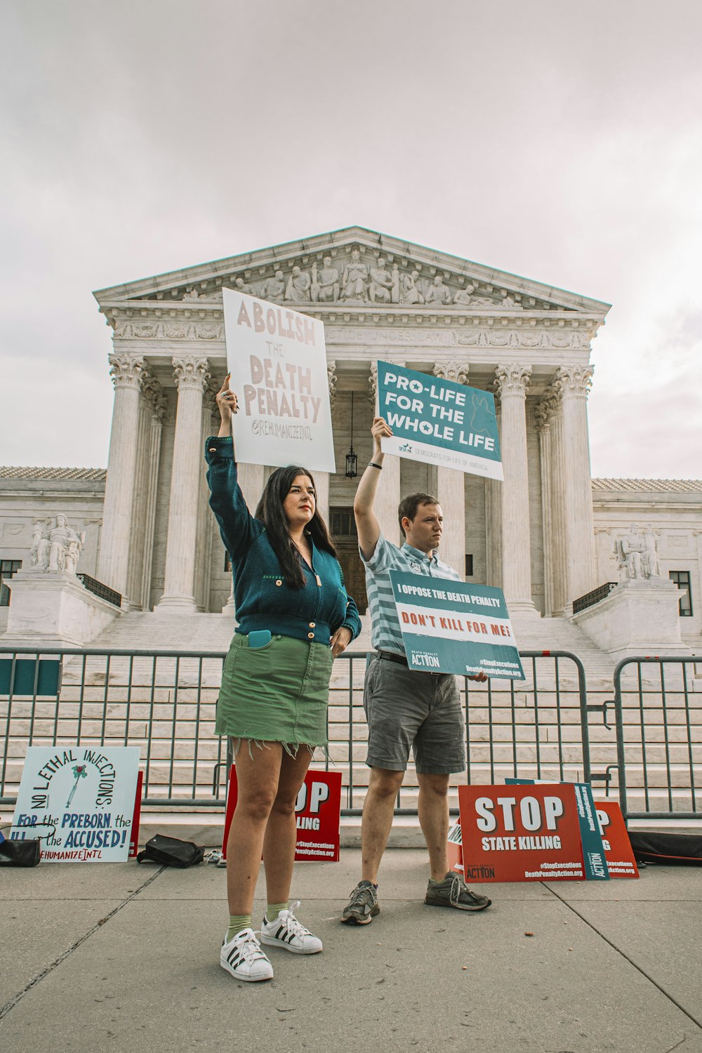 a couple of people holding signs in front of a building