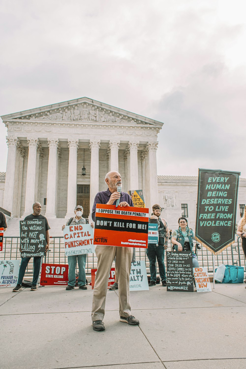 a man standing in front of a building holding a sign