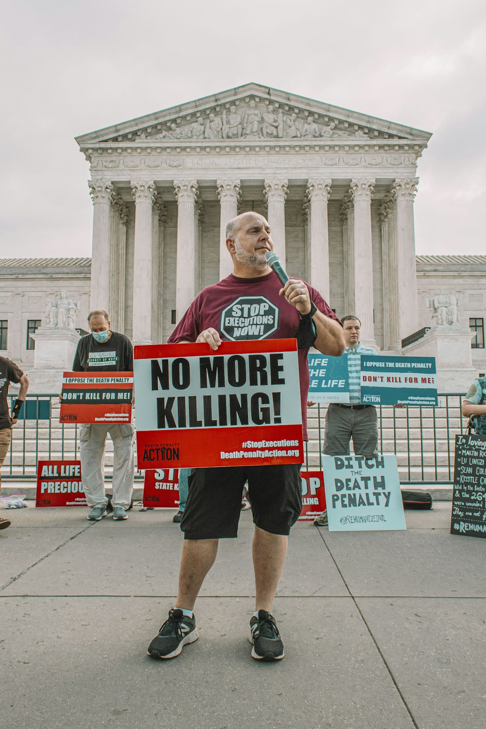 a man holding a sign that says no more killing