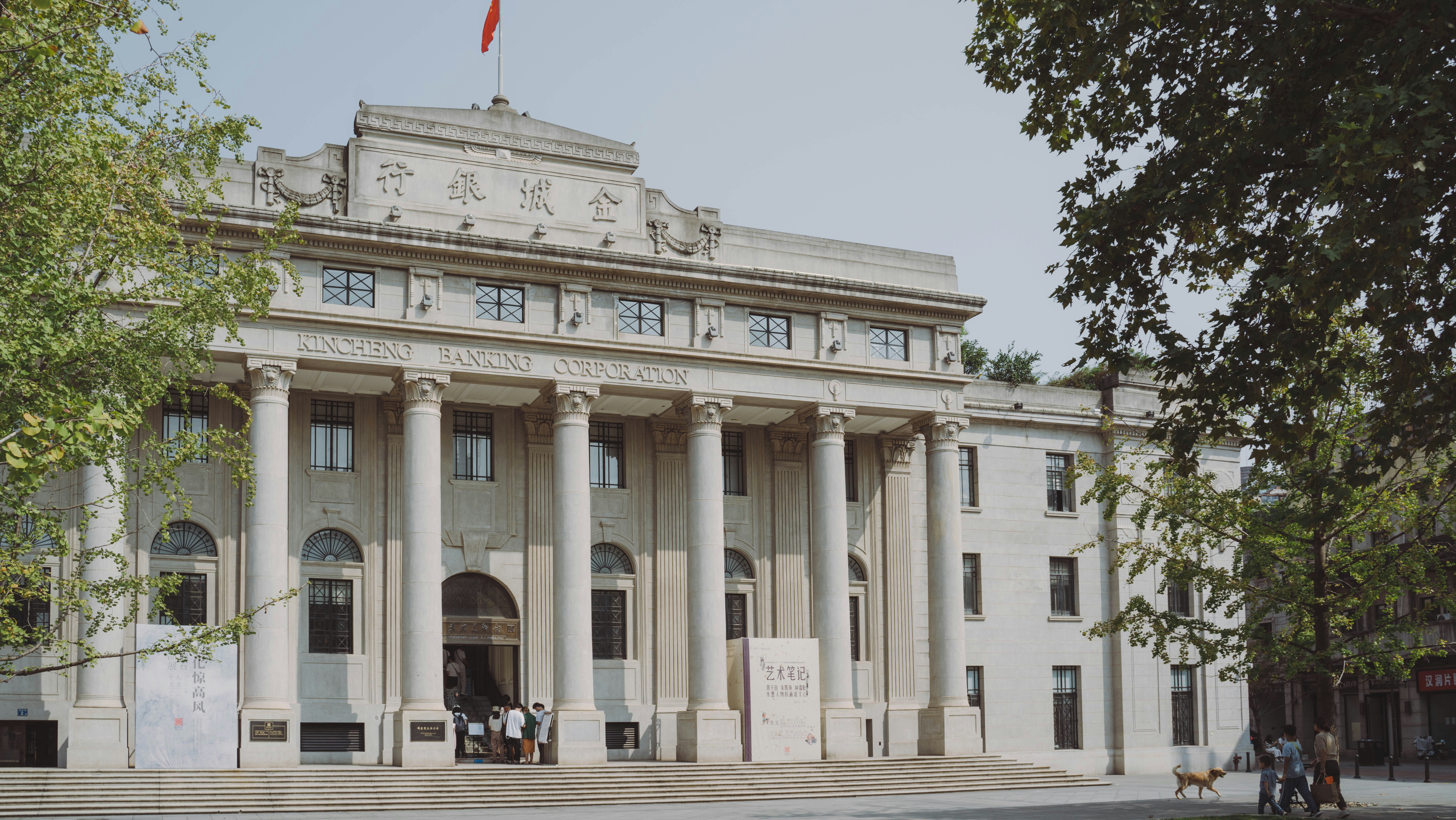 a large white building with columns and a flag on top of it