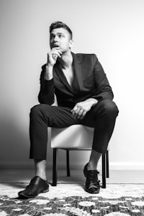a man in a suit sitting on a chair