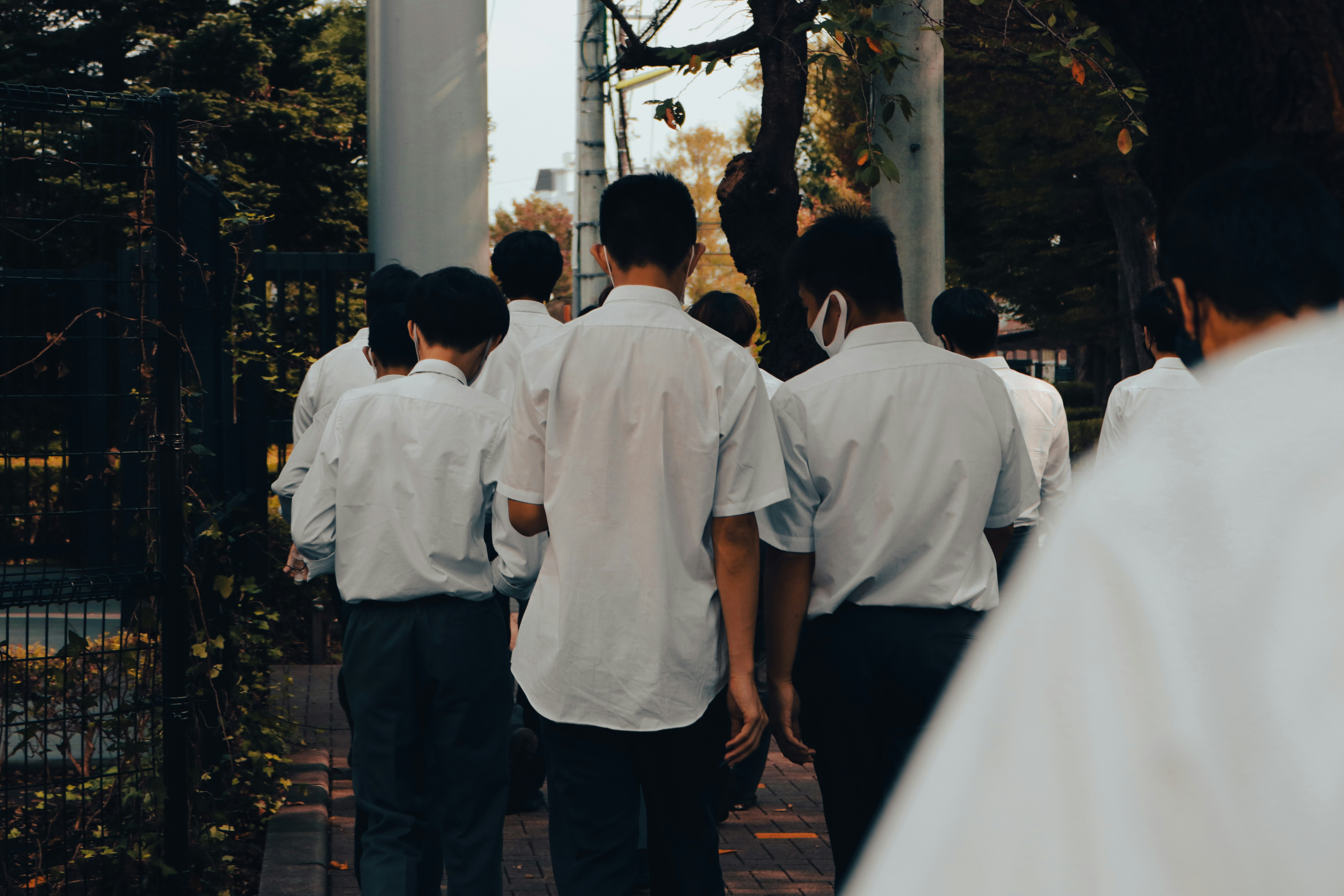 a group of young men walking down a sidewalk