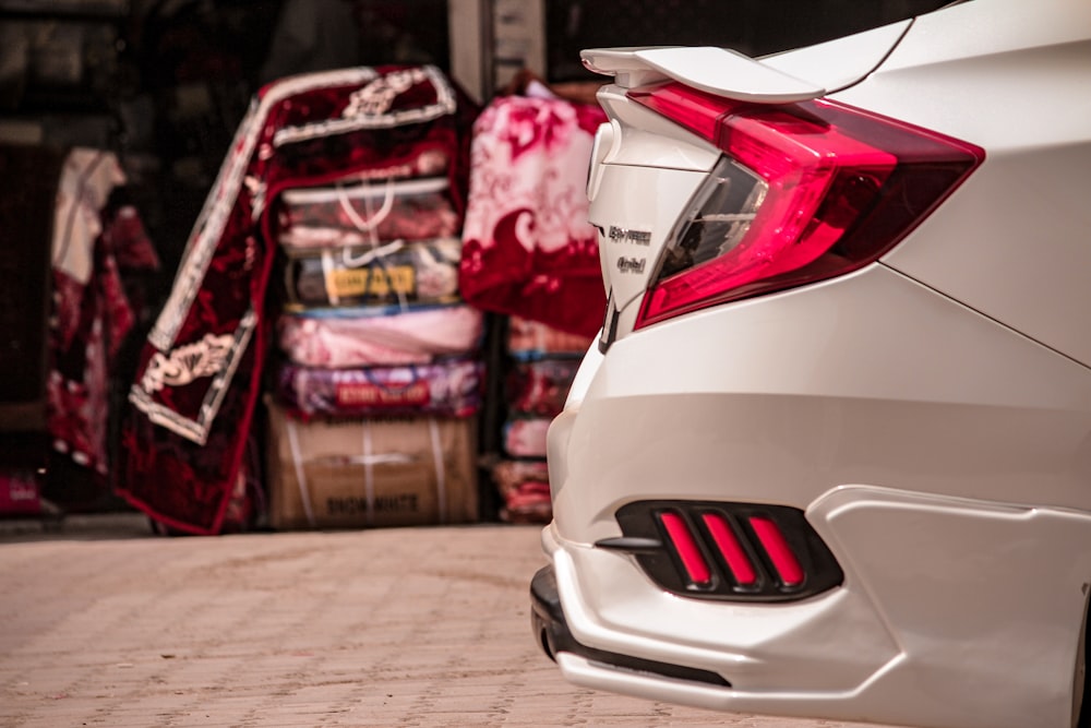 a white car parked next to a pile of luggage