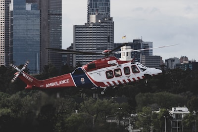 A sleek helicopter flying over a cityscape at dawn, symbolizing rapid medical air transport.