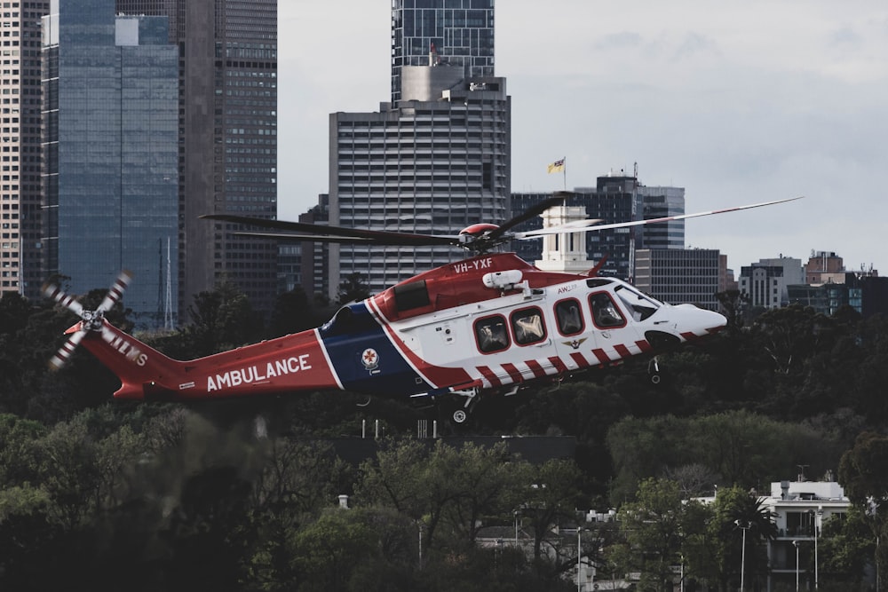 도시 상공을 비행하는 빨간색 흰색과 파란색 헬리콥터