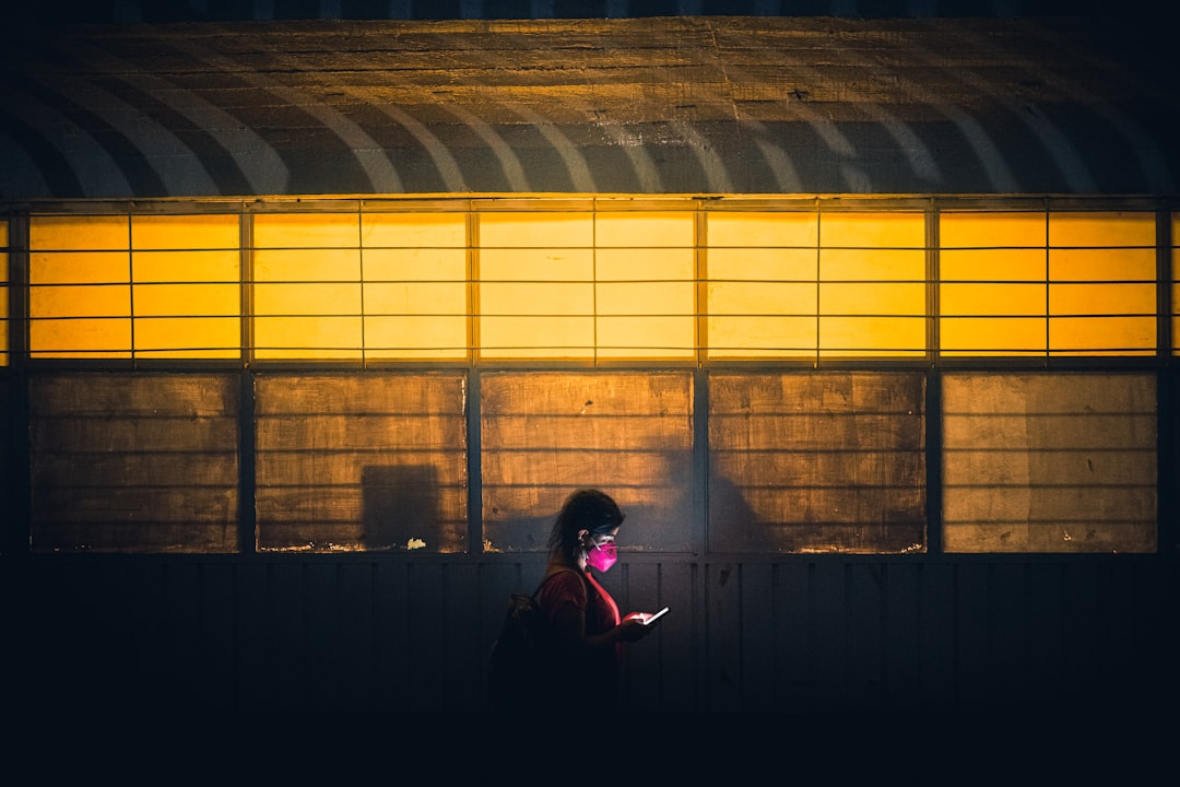 a person standing in front of a building with a cell phone,