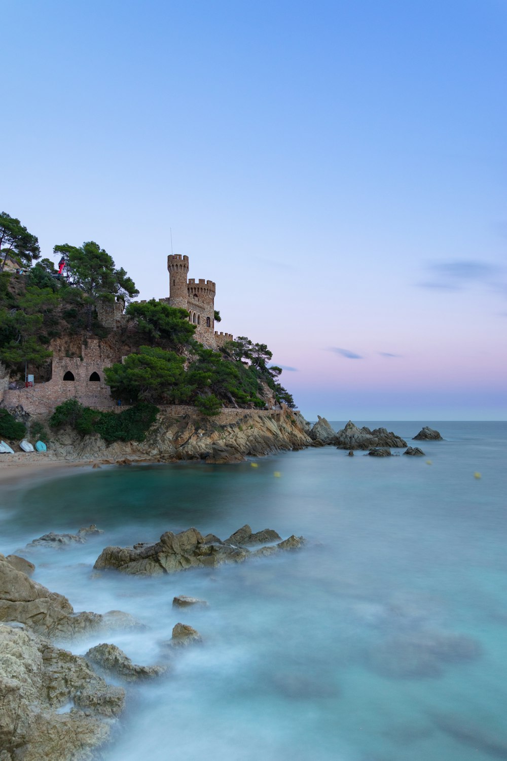 a castle sitting on top of a cliff next to the ocean