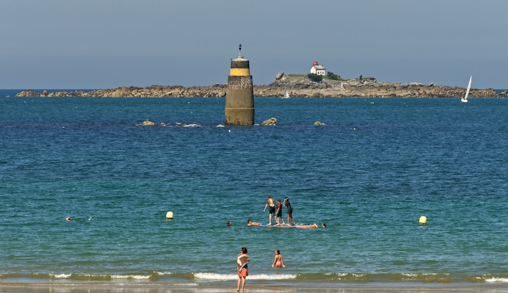 a group of people standing on top of a beach next to the ocean