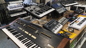 A collection of drum pads and synthesizers arranged on a wooden desk.