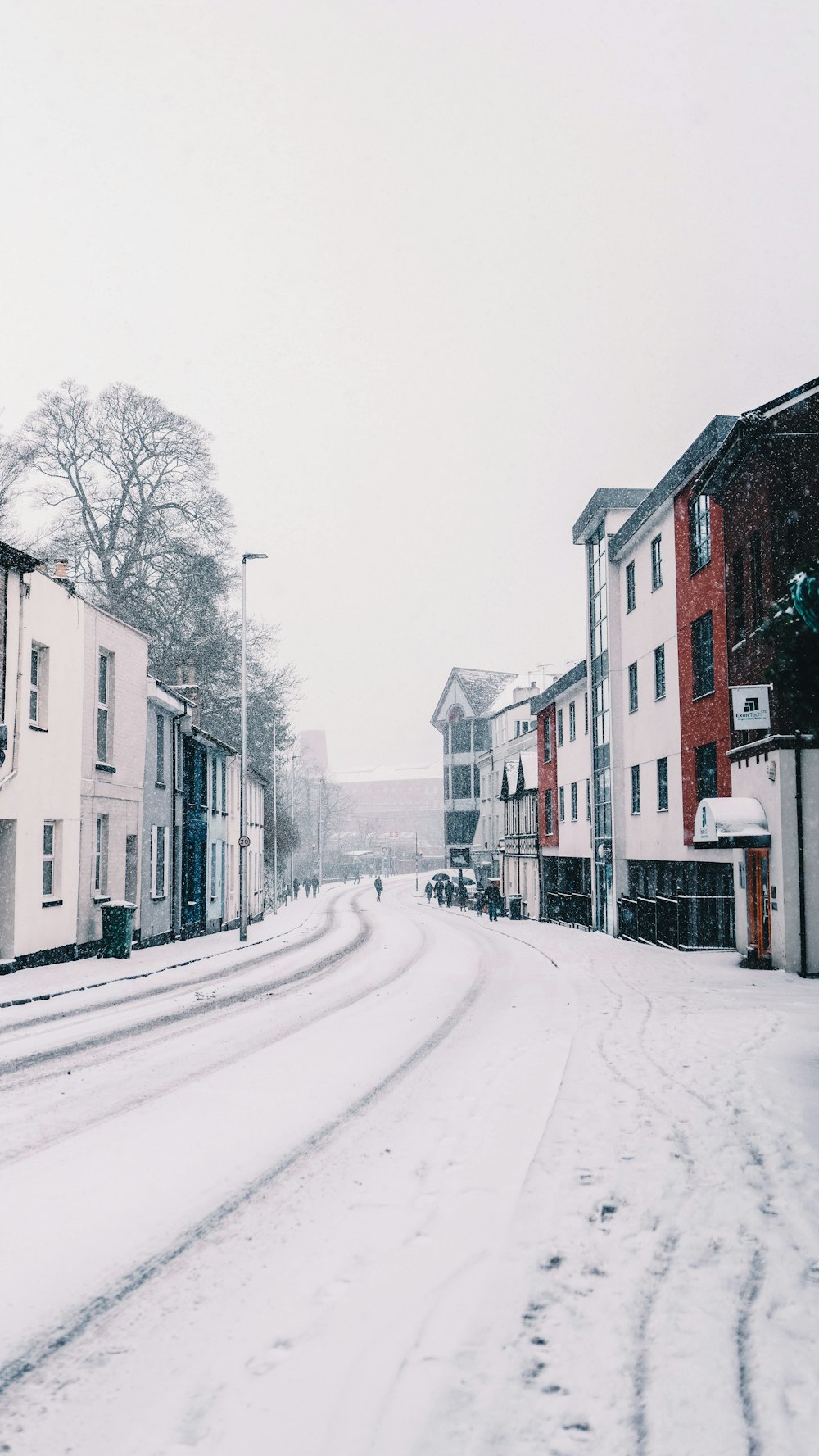 Una calle nevada con edificios y una farola