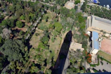 Aerial shot showing the proximity of a project location to the sea, with elegant shadows and lush greenery.