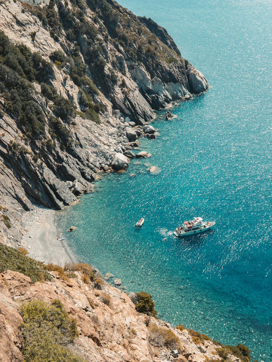Turquoise bay with an anchored boat seen from above, Tuscan coast