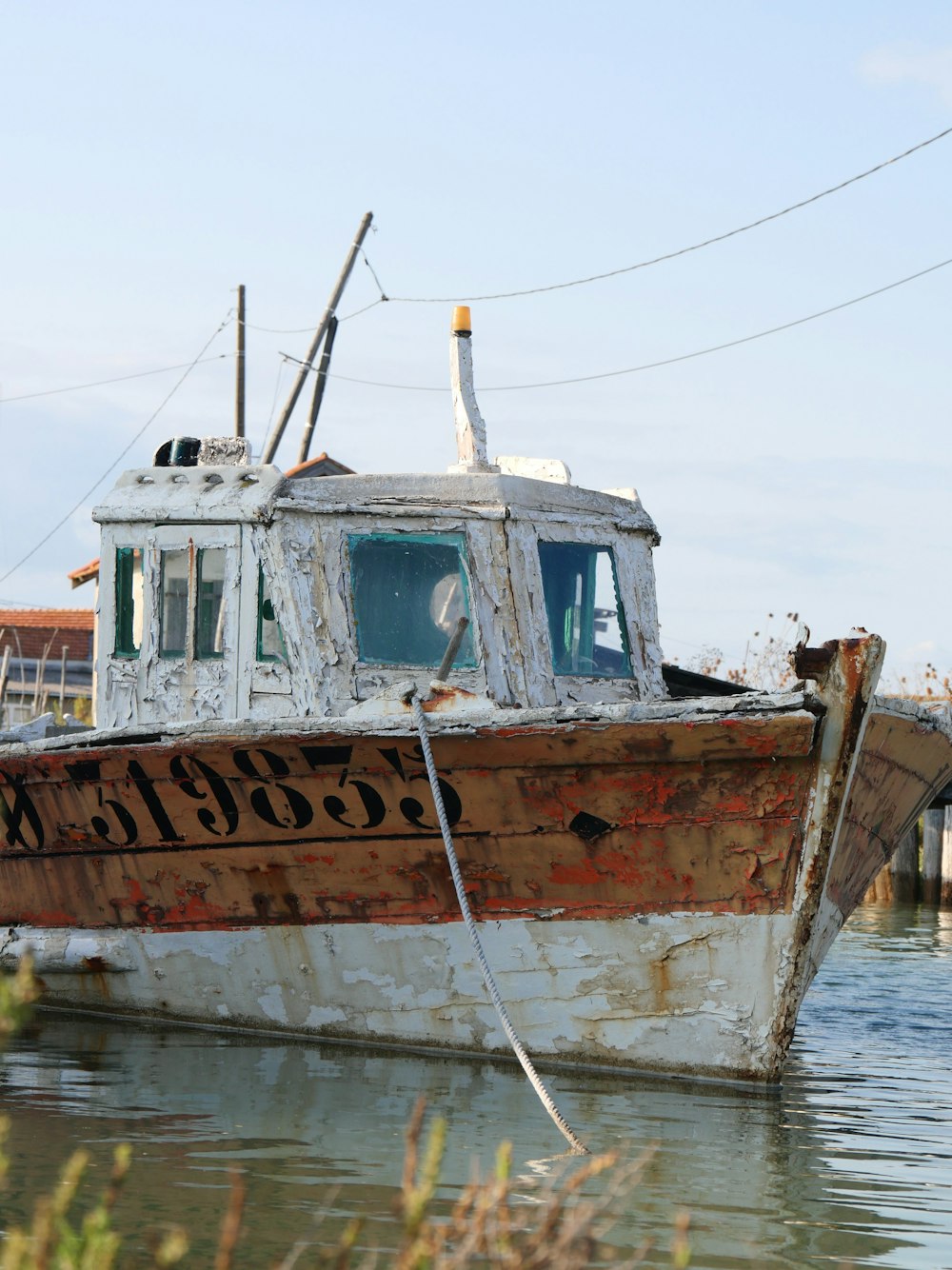 a rusted boat sitting in a body of water