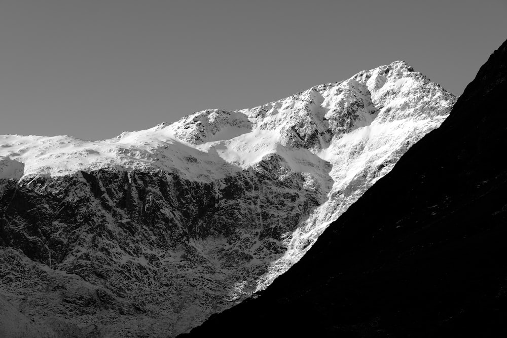 a black and white photo of a snow covered mountain