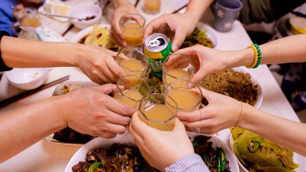 a group of people toasting with drinks at a dinner table
