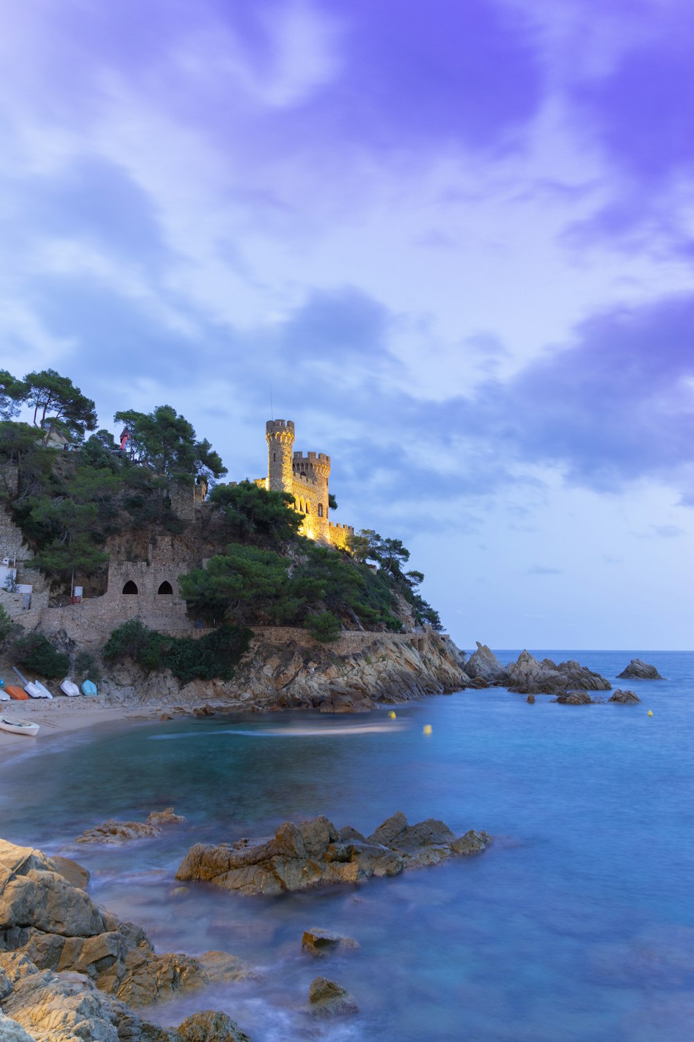 a castle sitting on top of a cliff next to the ocean