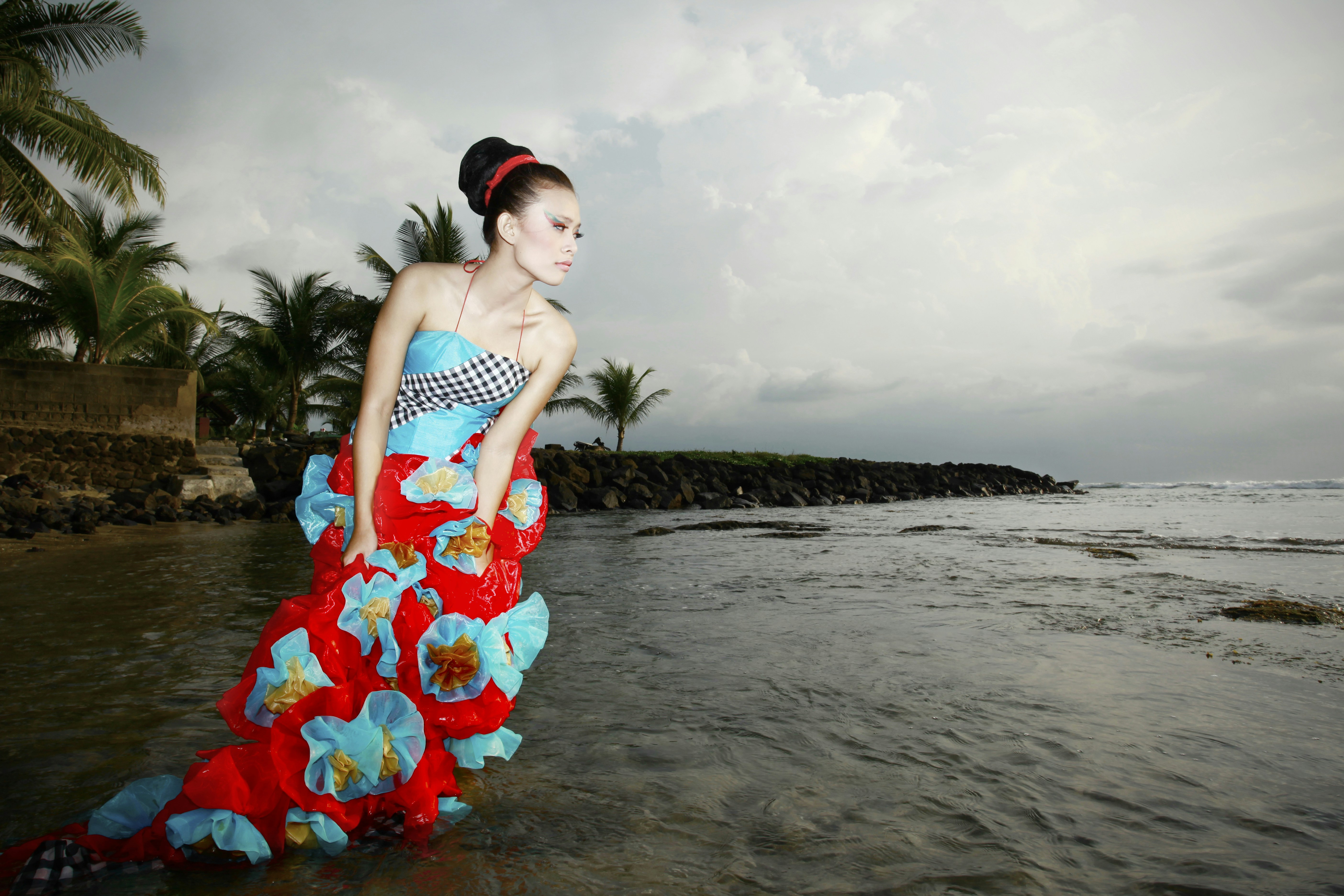 a woman in a red and blue dress standing in the water