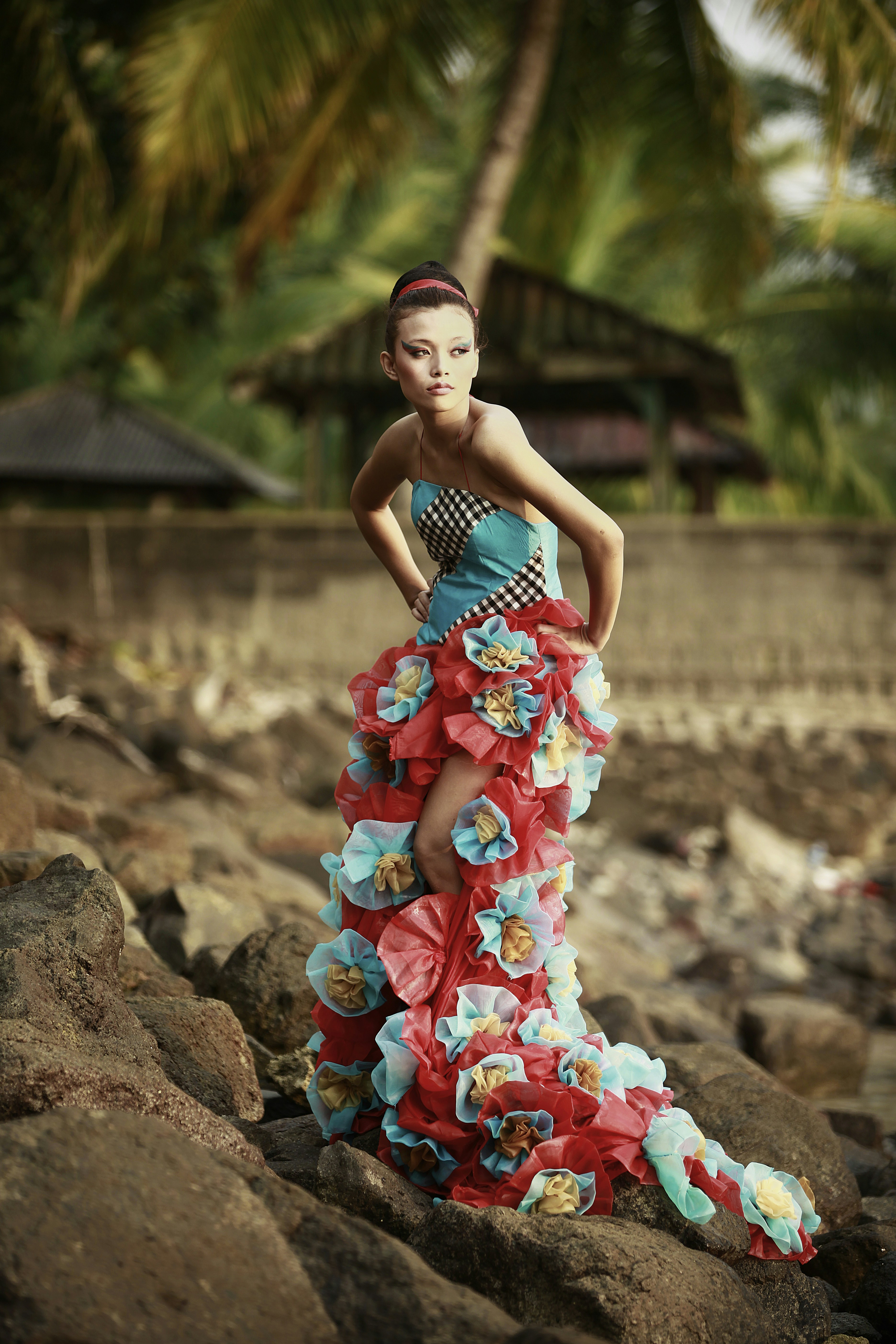 a woman in a dress standing on some rocks