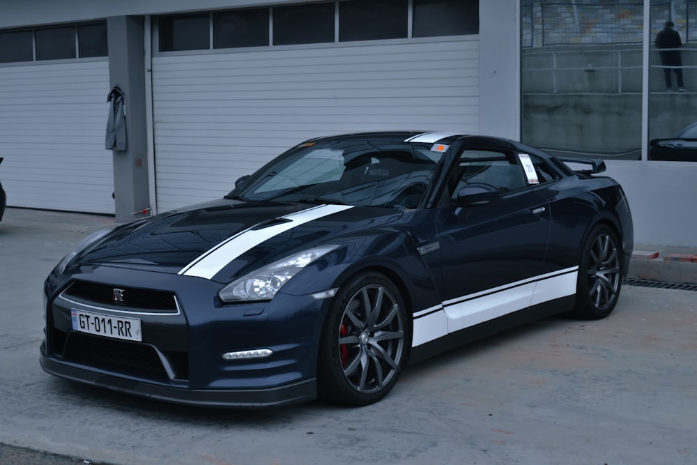 a blue sports car parked in front of a garage