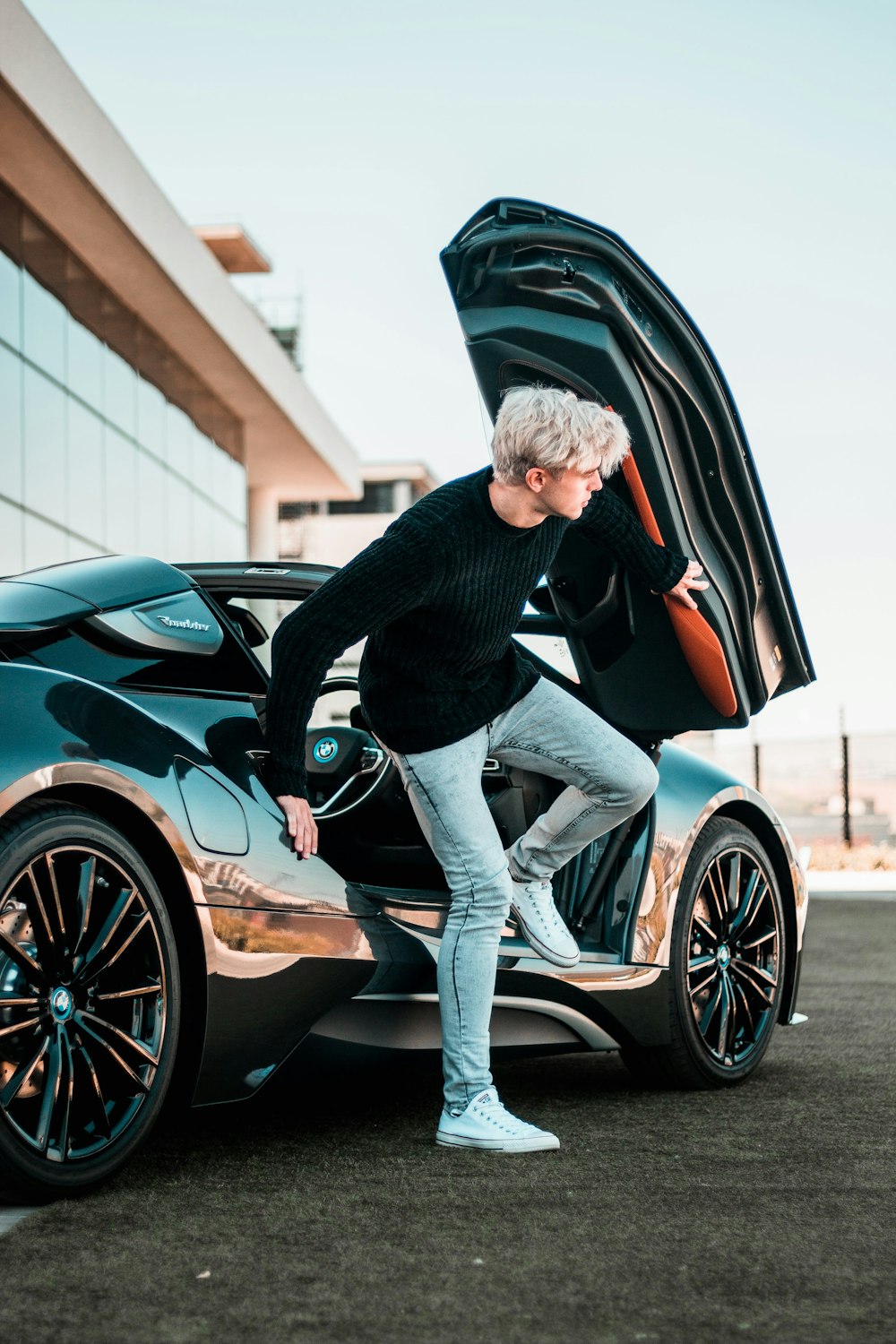 a man standing next to a car with its doors open