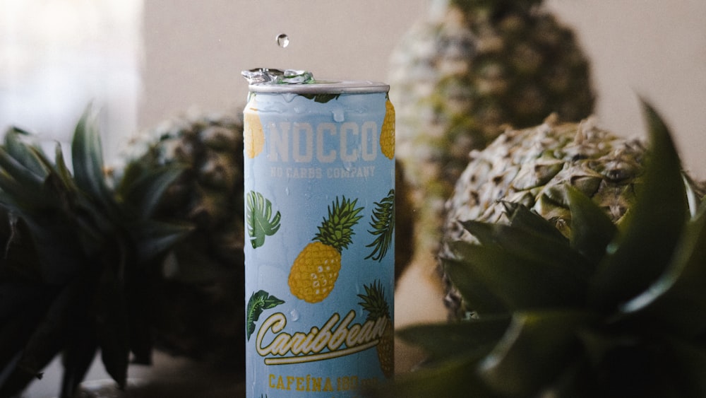 a can of pineapple soda next to a pineapple