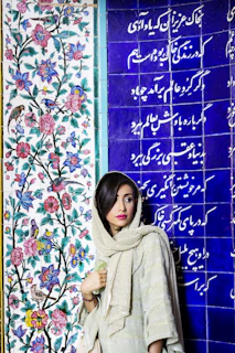 a woman standing in front of a colorful wall