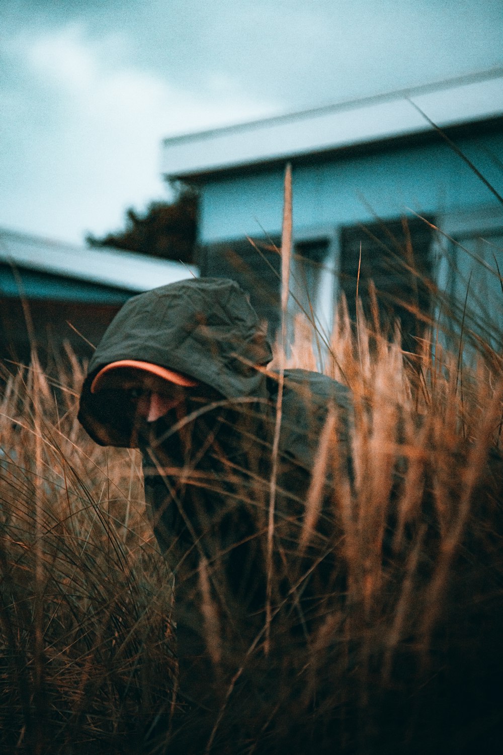 a person wearing a hat standing in tall grass