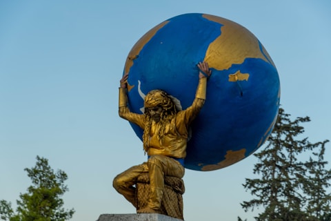 a statue of a person holding a large blue and gold globe