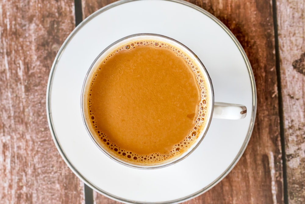 a cup of coffee sitting on top of a white saucer