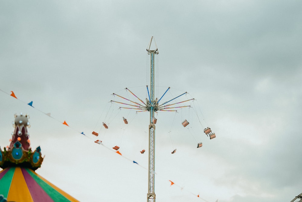 a carnival ride with a carnival carousel in the background