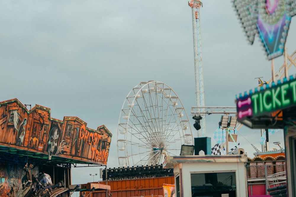 a carnival with a ferris wheel in the background