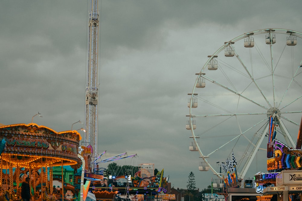 un parc d’attractions avec une grande roue et des manèges