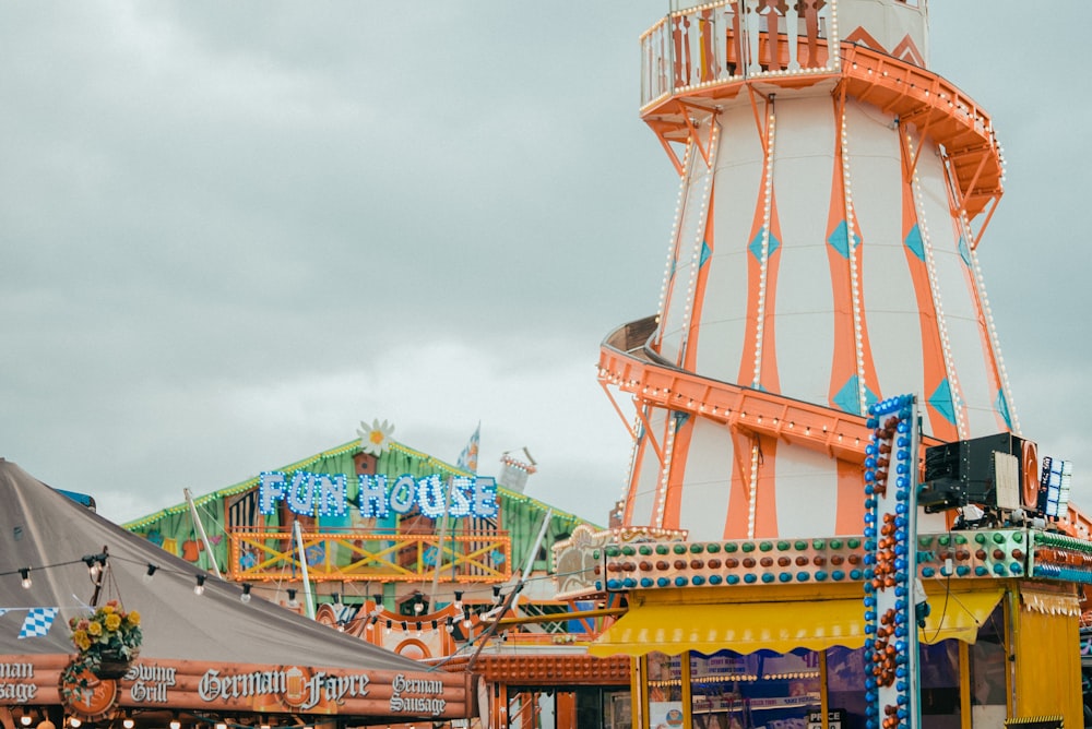 an amusement park with a large tower in the background