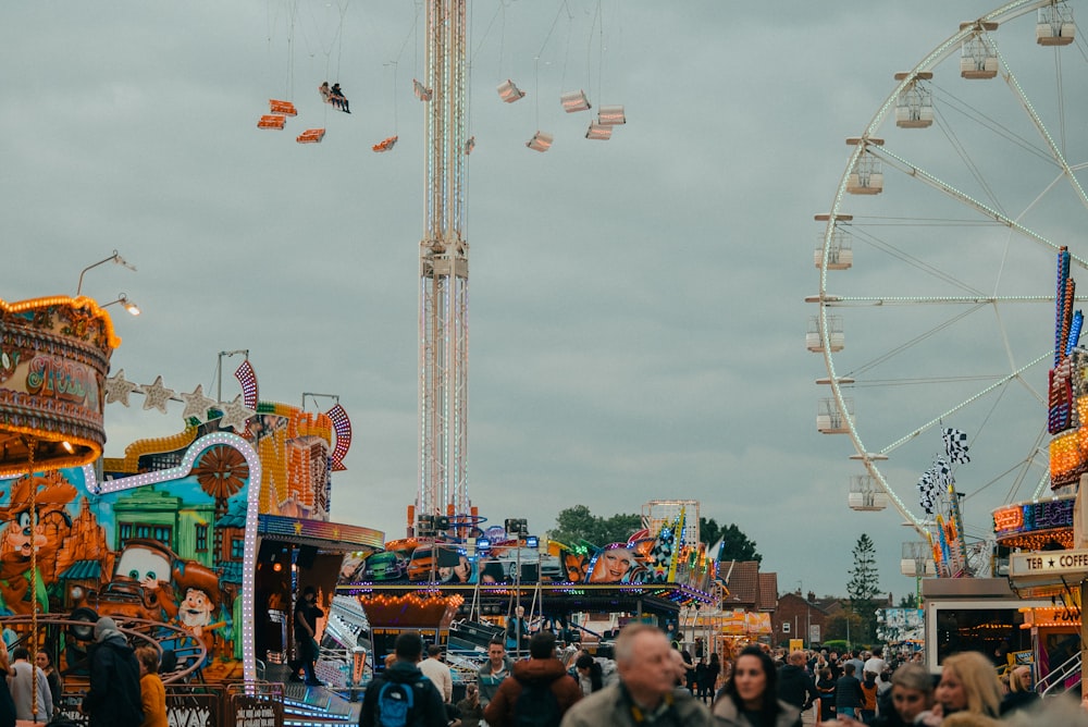 a crowd of people walking around a carnival