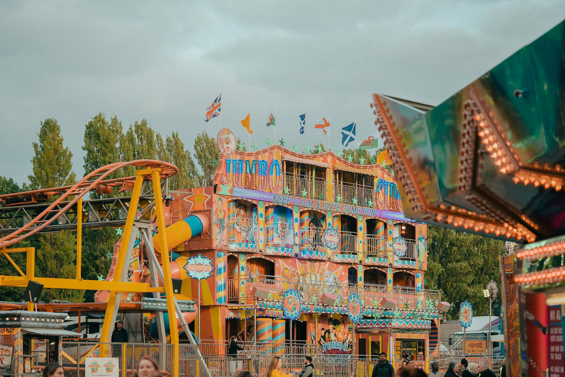 a carnival ride with a colorful building in the background