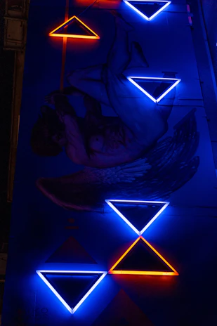 Dynamic shot of a phoenix-inspired mural glowing with light blue and gold accents on a modern academy wall.