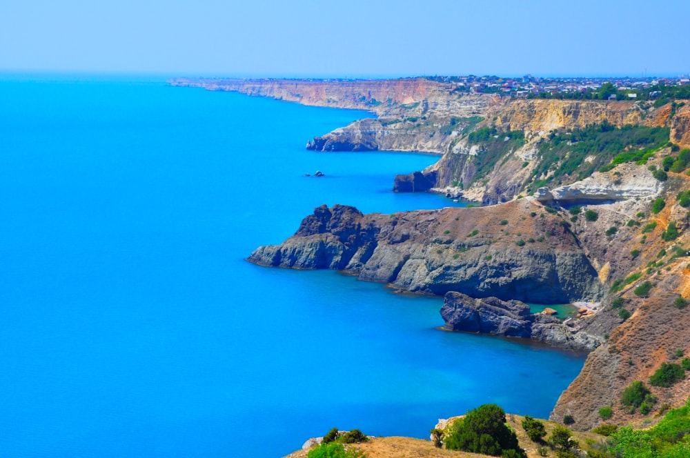 a scenic view of a blue ocean and cliffs