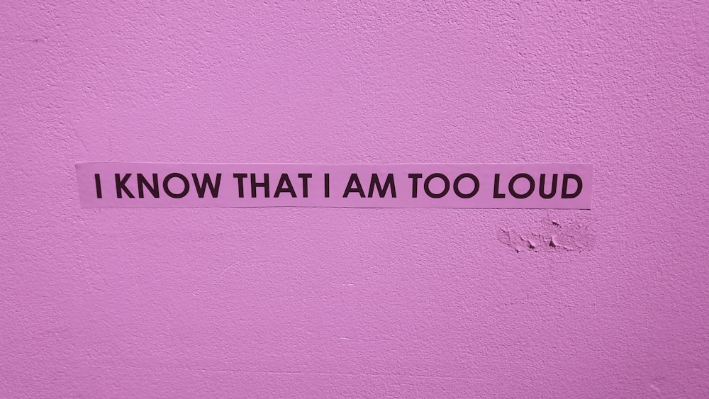 i know that i am too loud sticker on a pink wall