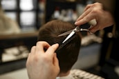 A hairstylist trimming a client's hair with precision in a cozy salon setting.