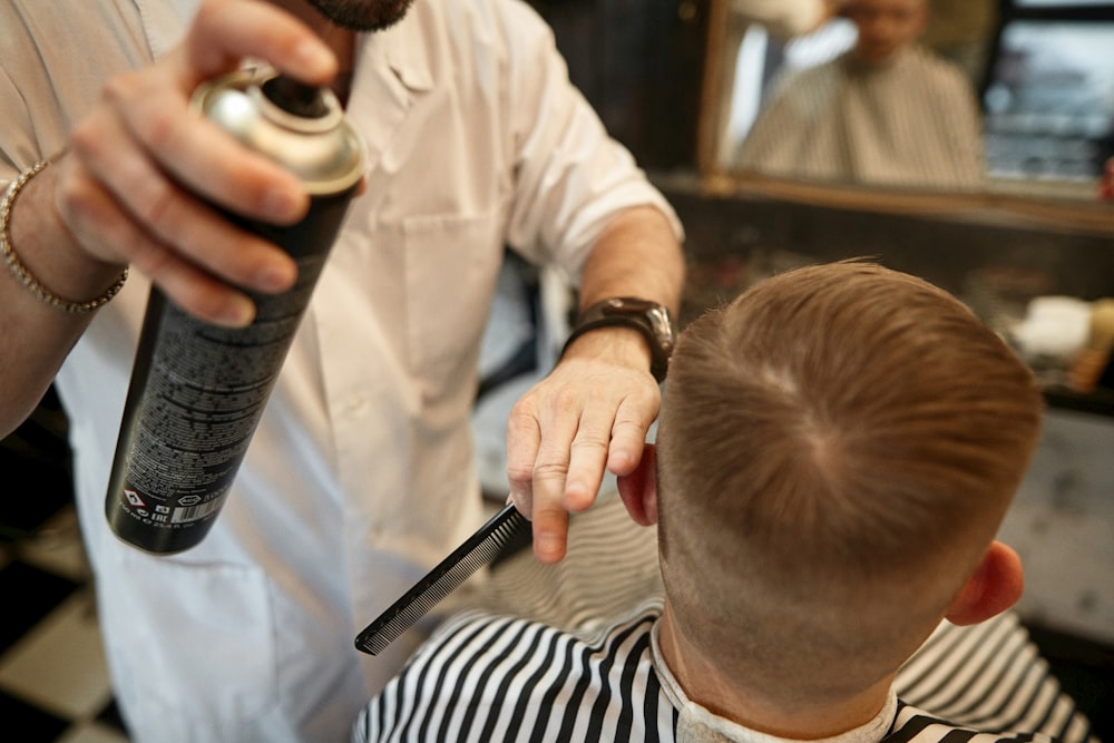 a man cutting another man's hair with a hair dryer