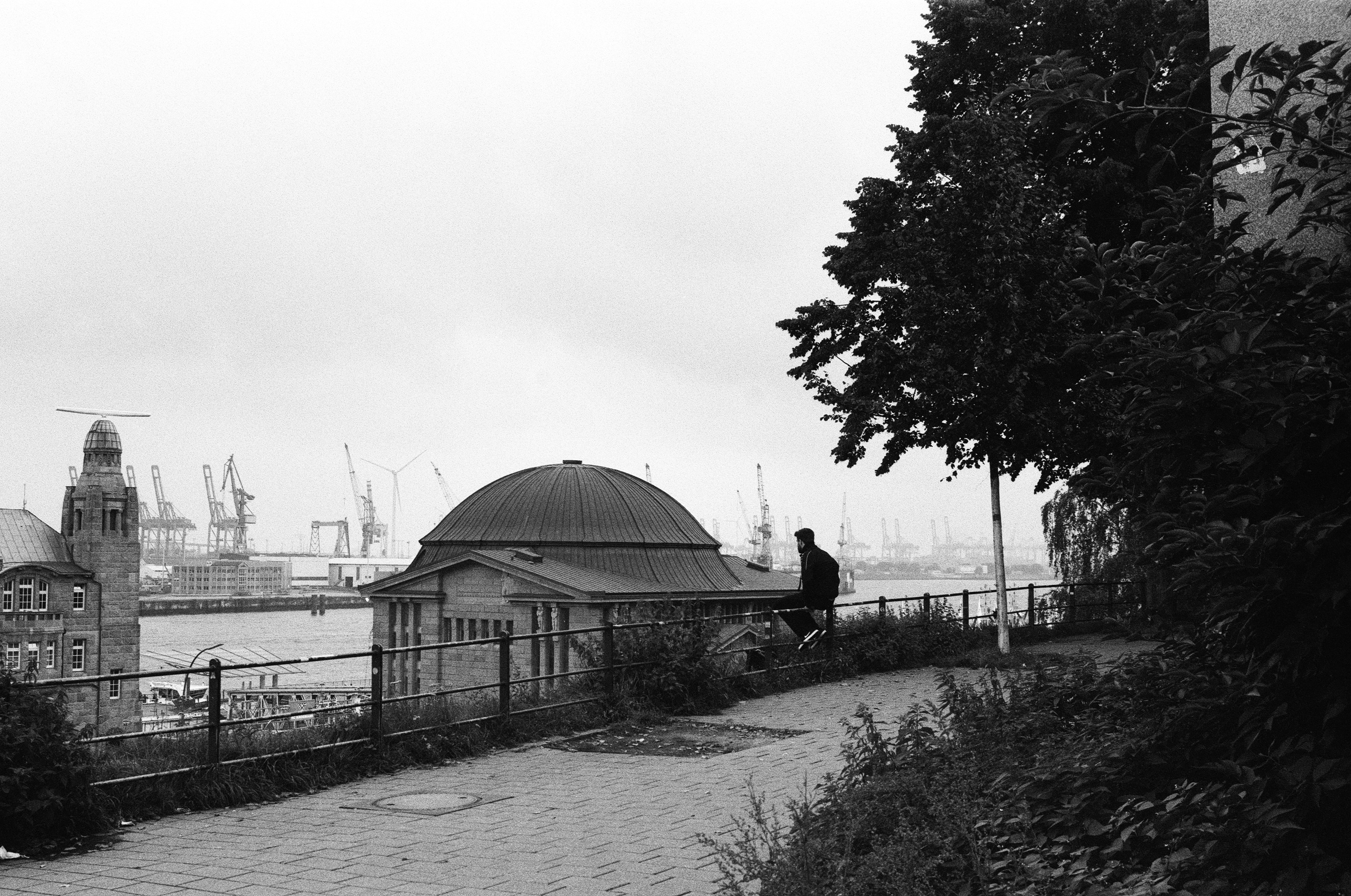a black and white photo of a man sitting on a bench