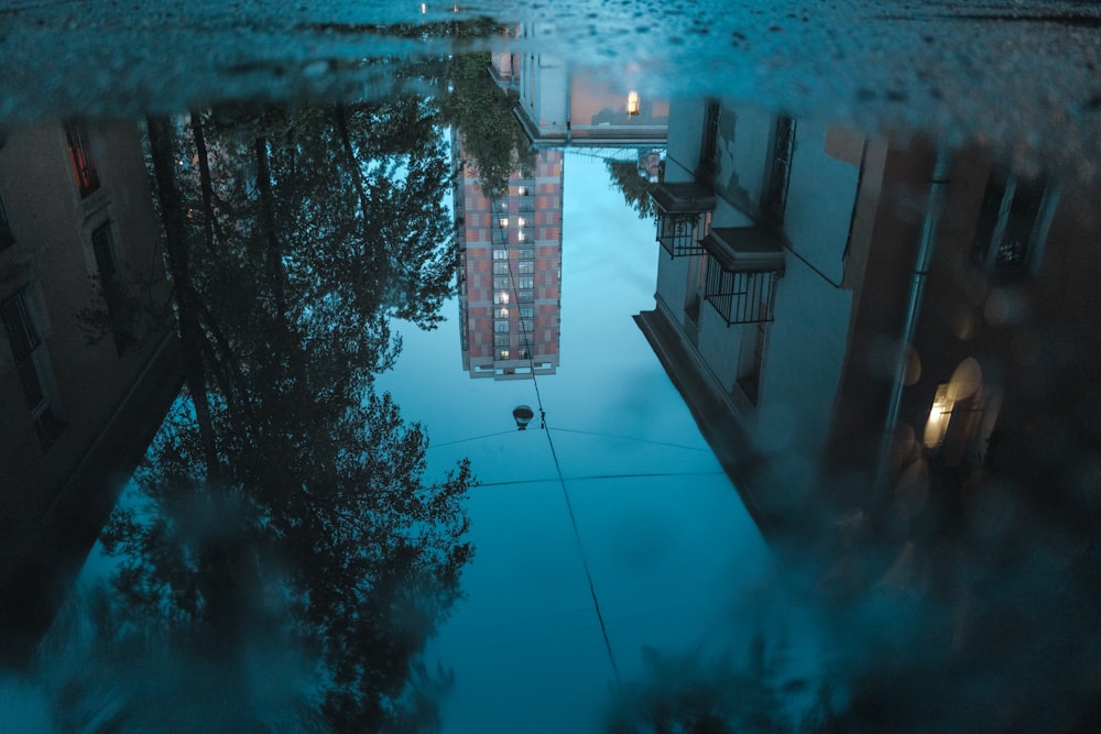 a reflection of a building in a puddle of water