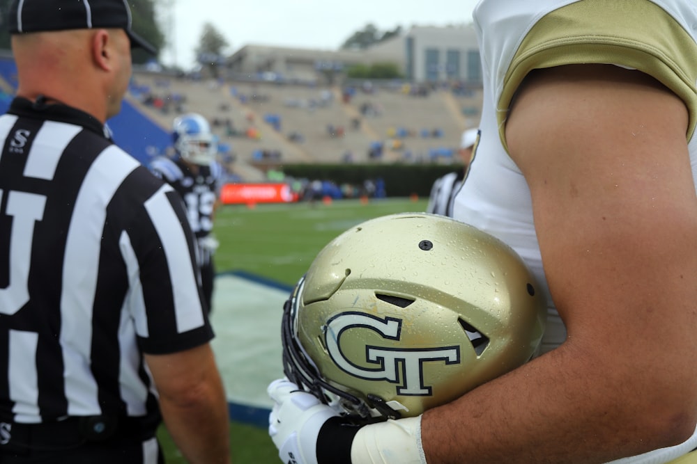 a football player holding a football on a field