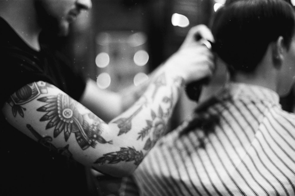 a woman getting a tattoo on her arm