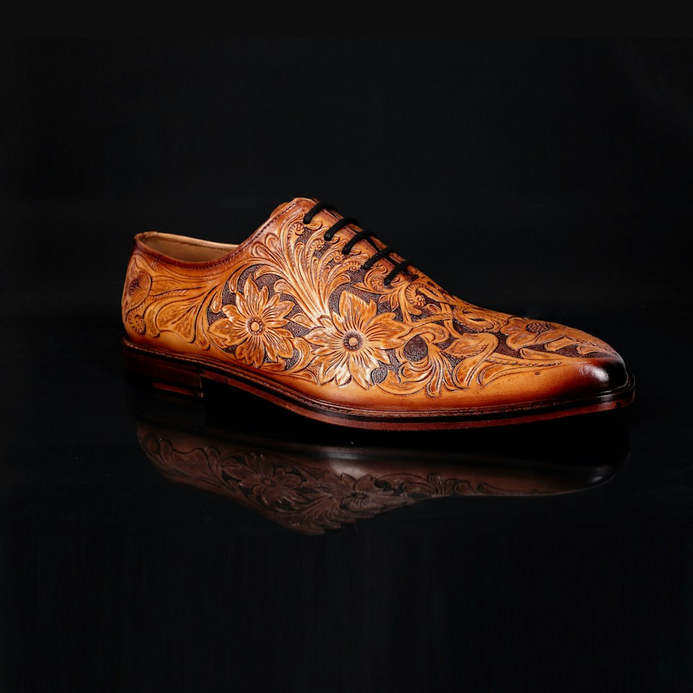 a brown shoe with a floral design on it