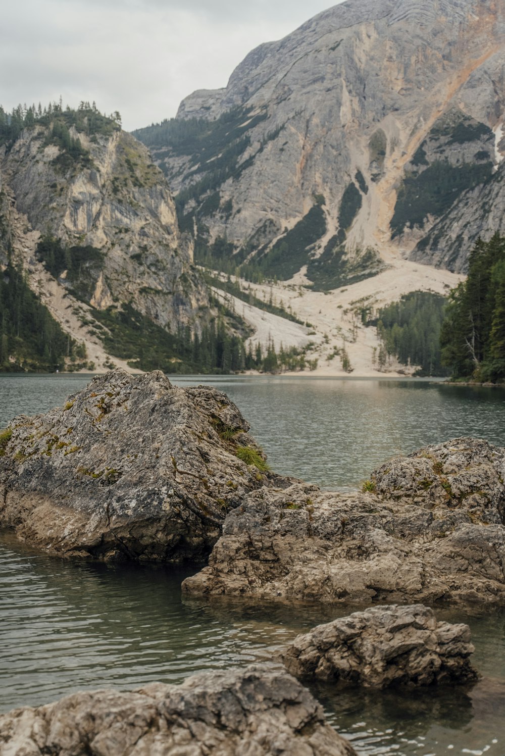 a man standing on a rock in the middle of a lake