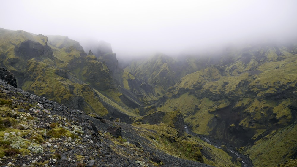 a foggy mountain with a river running through it