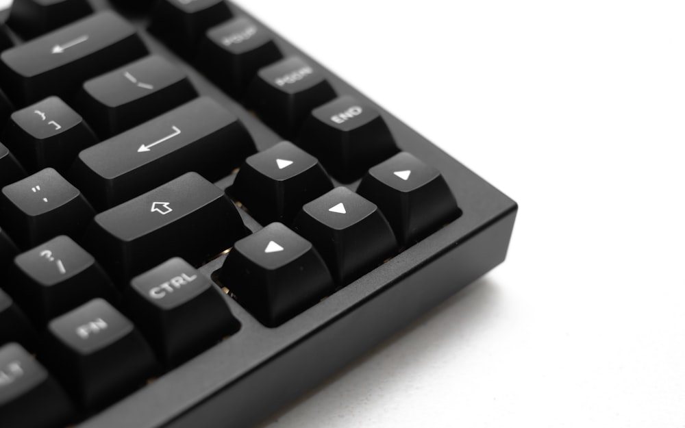 a close up of a black keyboard on a white surface