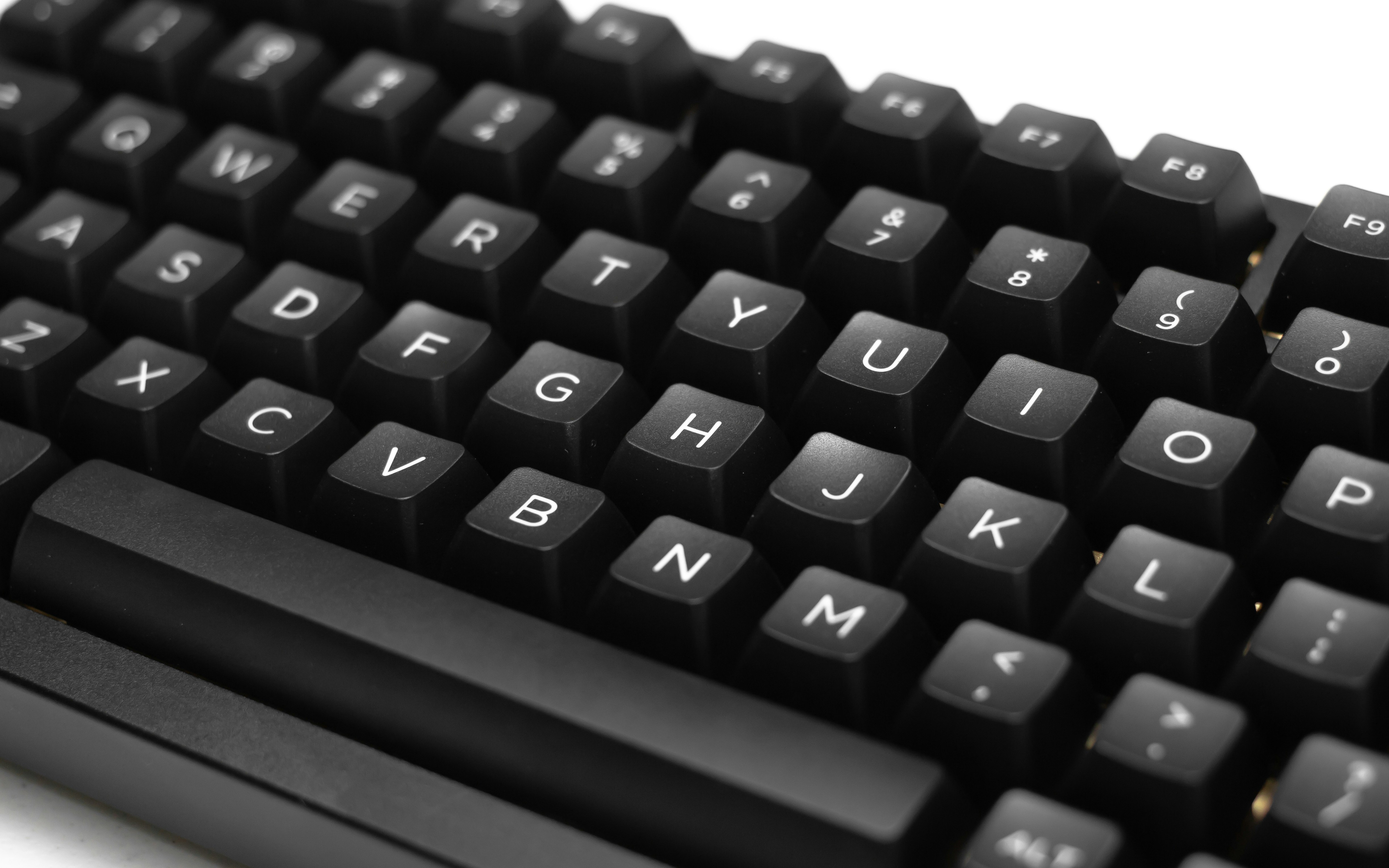 a close up of a black keyboard on a white surface